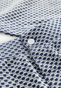 Marineblauw en wit gestreepte stof met een ruitpatroon, met een ronde witte knop op de kraag. Zachte textuur, casual stijl.