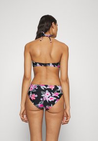 Juodas gėlių bikini su rožinėmis ir žaliomis gėlių raštais, su kaklo virvute ir vidutinio aukščio apatine dalimi, pagamintas iš tamprios medžiagos.