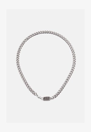 Silberne Halskette mit dicken Gliedern und einem rechteckigen Verschluss mit eingraviertem Tigerkopf-Design vor weißem Hintergrund.