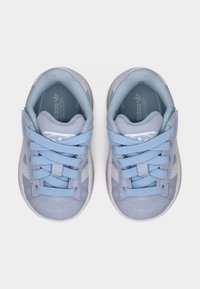 Μπλε σουέντ αθλητικά παπούτσια με υφή, κορδόνια στο ίδιο χρώμα και λευκή ρίγα στα πλαϊνά, με λαστιχένια σόλα.