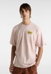 Helles rosa Baumwoll-T-Shirt mit kurzen Ärmeln, mit gelbem, gesticktem "Vans Off The Wall"-Logo auf der Brust. Lockerer Schnitt.