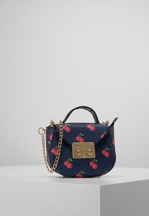 Navy blue small handbag with red cherry print, gold-tone clasp, gold chain strap, and a short top handle on a white surface.