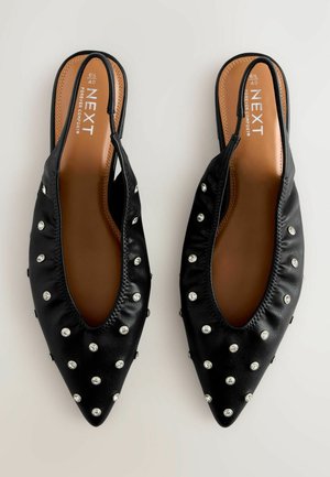 Mustad sünteetilised sussid, millel on terav nina ja ehtena ülemisel osal hõbedased nurgad, mis lisavad ekstra stiili.