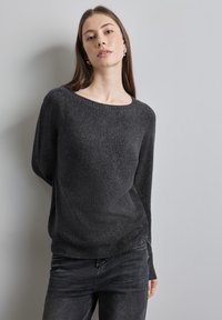 Maglione lavorato a maglia grigio scuro con scollatura ampia e maniche lunghe. Tessuto morbido, vestibilità comoda e dettaglio a coste sull'orlo, abbinato a jeans scuri.