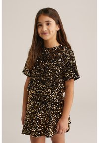Czarna sukienka pokryta złotymi i brązowymi cekinami, z krótkimi rękawami i luźnym krojem, z okrągłym dekoltem i falbaną u dołu.