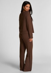 Bruin geribbelde gebreide trui en bijpassende broekset met lange mouwen en een wijde broekontwerp, met een comfortabele pasvorm en een gestructureerde stof.