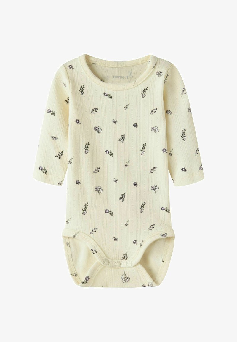Body pour bébé de couleur crème avec manches longues, petits motifs floraux, texture côtelée et boutons-pression à l\'ourlet pour la fermeture.