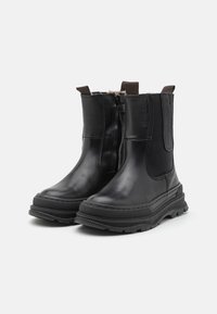 Black leather ankle boots with elastic side panels, zip closure, textured rubber soles, and pull tabs on the heel for easy wear.