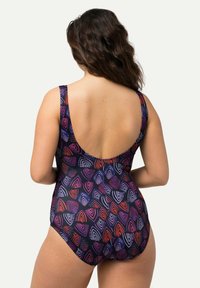 Yhdenpalaisen uimapuvun tumman violetin väri, jossa on monivärisiä abstrakteja aalto-kuvioita. Siinä on matala selkäosa ja leveät hihnat tukemiseen. Sujuva kankaan pinta.