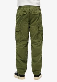 Cargo pants in olijfgroen met een elastische tailleband, meerdere zakken en taps toelopende enkels; gemaakt van lichtgewicht, duurzame stof.