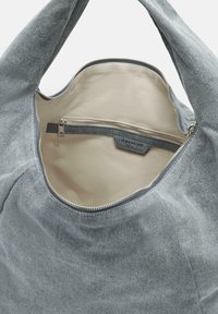 Szara torba dżinsowa o gładkiej fakturze, z kremowym, podszytym wnętrzem i małą kieszenią zapinaną na zamek wzdłuż wewnętrznej szwu.