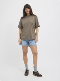 Bruine oversized t-shirt, denim shorts, grijze sokken en zwarte schoenen met bruine zolen. Eenvoudig ontwerp, casual pasvorm en neutraal kleurenpalet.