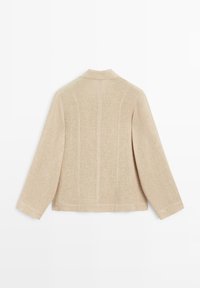 Beige langærmet jakke med stående krave, synlig vertikal syning og en let struktureret stof, vist fra ryggen.