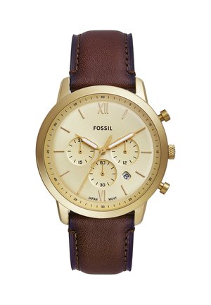 Goudkleurig Fossil polshorloge met bruine leren band, drie subdials, datumvenster en Romeinse cijfers XII en VI op een crèmekleurige wijzerplaat.