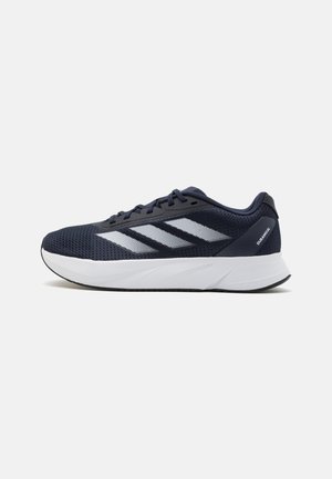 Czarno-biały but do biegania Adidas z siateczkową cholewką, trzema białymi paskami po boku i grubą, amortyzowaną podeszwą.