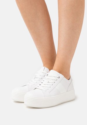 Sneakers platform bianchi realizzati in materiale sintetico liscio, con chiusura con lacci, dettagli laterali e una suola testurizzata e rigata.