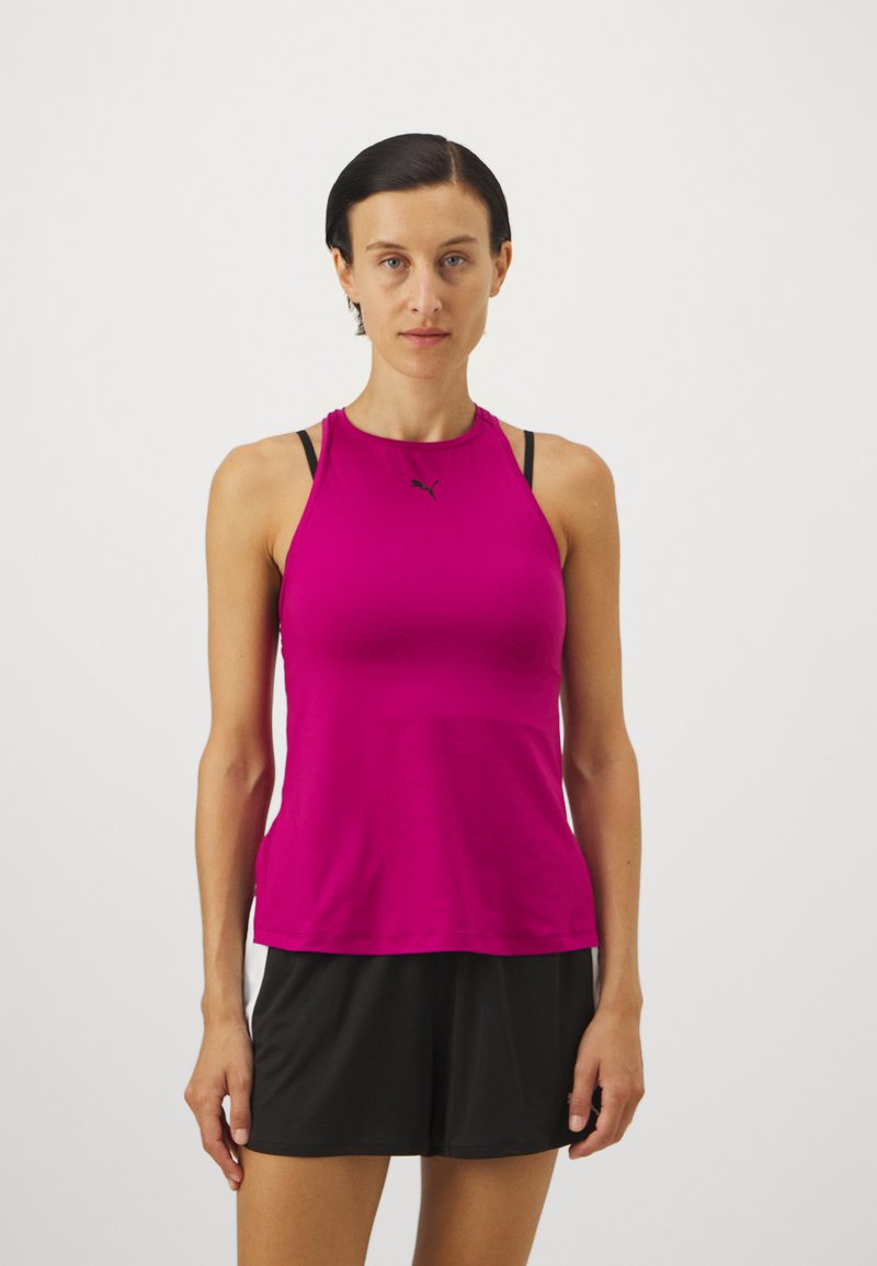 Fuchsia träningslinne med hög halsringning, racerryggdesign och svart logotyp. Bärs med svarta shorts med en mjuk textur.