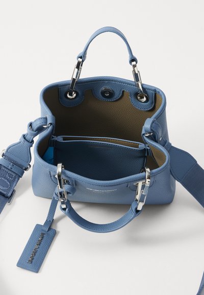 Borsa a mano in pelle azzurro chiaro con dettagli in argento, doppi manici superiori, tracolla rimovibile e interno spazioso con foderatura marrone e dettaglio con logo.