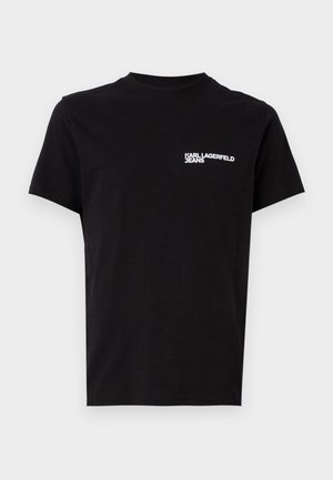 T-shirt preta feita de algodão, com gola redonda e mangas curtas. Texto de logótipo branco notável na área do lado esquerdo do peito. Design simples.