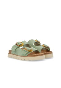 Green suede sandals with two adjustable strap closures and rounded yellow accents, resting on a light tan textured sole.