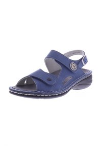 Blauer Sandale aus einem weichen, suedemähnlichen Material, offenes Zehendesign, verstellbare Riemen und eine gepolsterte Sohle. Besitzt markante runde Beschläge.