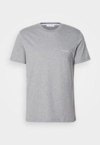T-shirt en coton gris avec col rond, manches courtes et petit logo Calvin Klein blanc sur la poitrine gauche. Texture douce.