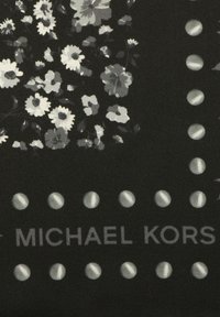 Czarny materiał z motywem kwiatowym w odcieniach szarości, z okrągłymi akcentami oraz nazwą marki "Michael Kors" w szarym tekście.