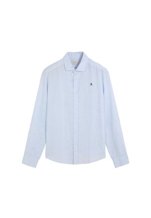 Camisa de manga larga azul claro con botones, cuello y pequeño logo de calavera negra en el lado izquierdo del pecho contra un fondo blanco.