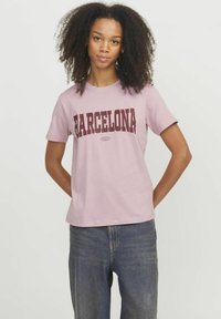 T-shirt rosa chiaro con la scritta "BARCELONA" stampata in lettere bold color bordeaux. Maniche corte, collo rotondo e tessuto di cotone morbido. Vestibilità casual.