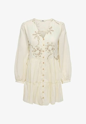 Robe crème à manches longues avec boutonnage devant, jupe à volants et motifs floraux brodés sur le corsage.