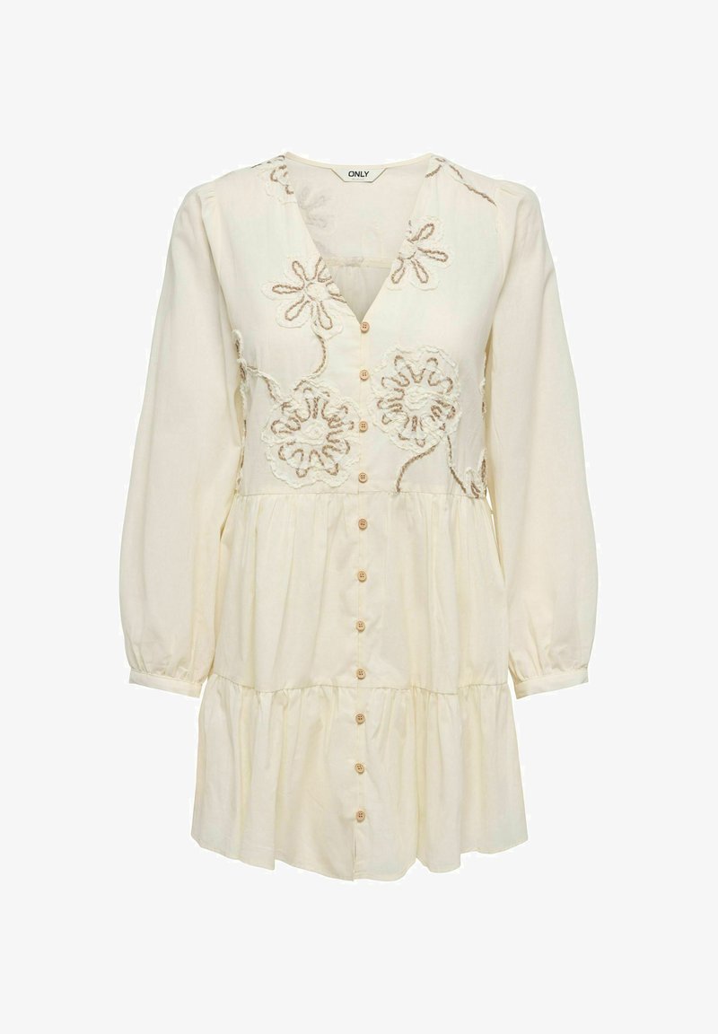 Robe crème à manches longues avec boutonnage devant, jupe à volants et motifs floraux brodés sur le corsage.