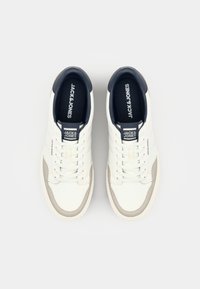 Witte leren sneakers met een grijs suède accent, ronde neus en vetersluiting. Heeft een marineblauwe hielkraag en logodetail op de tong.