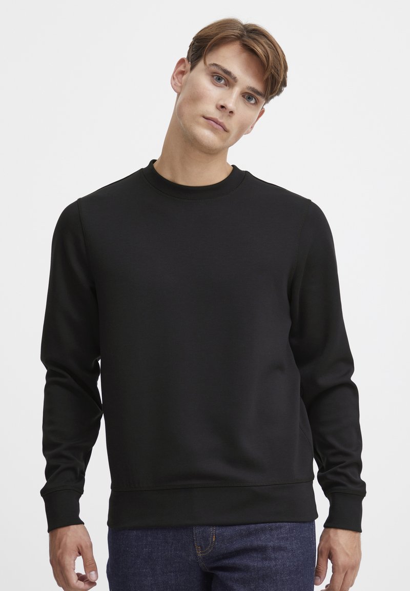 Black sweatshirt with a round neck and long sleeves. Made from smooth, lightweight fabric; features ribbed cuffs and hem.