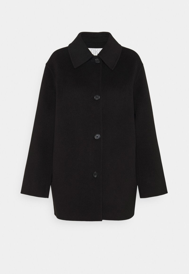 Černý oversized kabát vyrobený z měkké látky, s velkým límcem, předním zapínáním na knoflíky a dvěma náprsními kapsami. Čistý, minimalistický design.