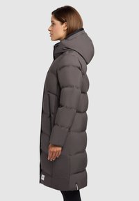 Long grey puffer coat with a hood, featuring a quilted design, zipper pockets, and ribbed cuffs. The material has a smooth texture.