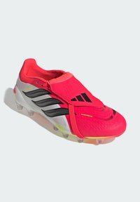 Φωτεινό κόκκινο και λευκό ποδοσφαιρικό παπούτσι Adidas Predator με μαύρες ρίγες και διαφανή καρφιά, με σχέδιο καλυμμένων κορδονιών.