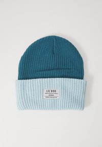 Tyrkysovo a svetlomodré rebrované pletené čiapky s prehnutým okrajom a štítkom, na ktorom je napísané "LIL'BOO DANISH DESIGN STUDIOS COPENHAGEN."