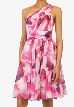 Mujer con un vestido sin mangas, de un solo hombro, con estampado floral rosa y blanco, corsé ajustado y falda acampanada.