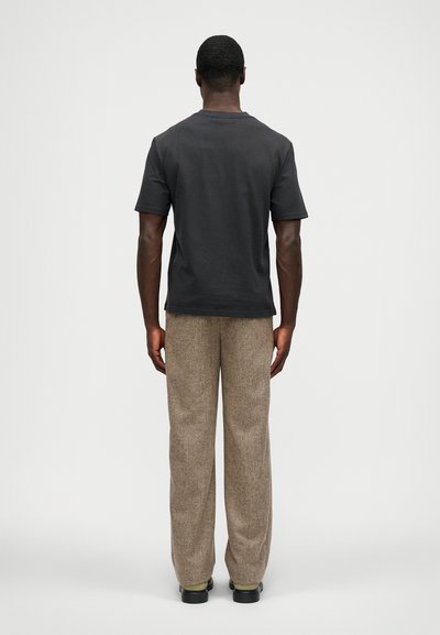 Γκρι κοντομάνικο βαμβακερό μπλουζάκι συνδυασμένο με ανοιχτό καφέ υφασμάτινο παντελόνι, με χαλαρή εφαρμογή και ίσια γραμμή.