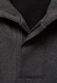 Felpa grigia con zip, dalla superficie testurizzata, colletto rialzato e zip a contrasto. Caratterizzata da un colore uniforme e linee pulite.