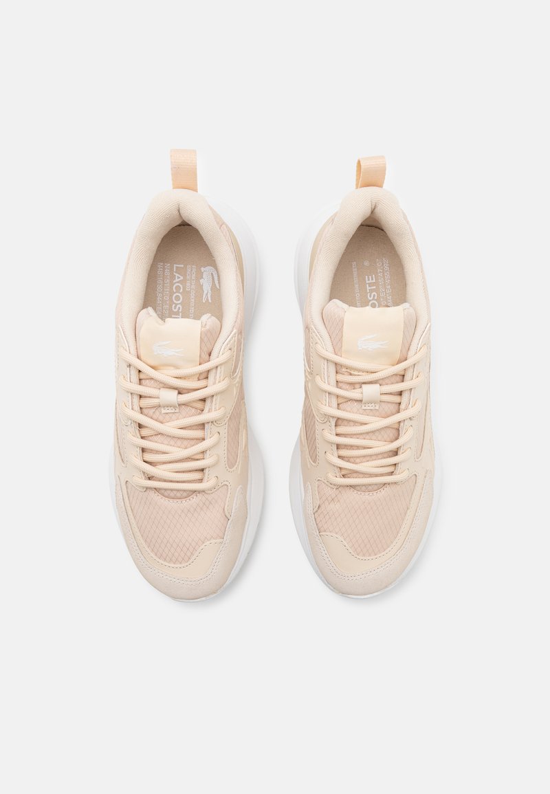 Baskets de sport beiges en matériau synthétique et en mesh, à bout rond, col rembourré et détails texturés. Semelle extérieure blanche et lacets.