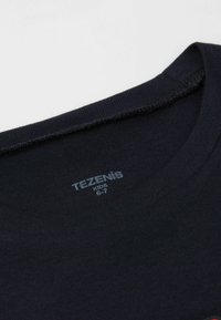Námořnická modrá bavlněná tričko s kulatým výstřihem. Hladká textura, štítek uvnitř límce čte "TEZENIS KIDS 6-7".