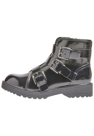 Stivale alla caviglia in pelle verniciata nera con tre fibbie decorative, chiusura con zip e suola in gomma spessa con un motivo di battistrada testurizzato.