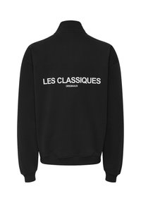 Felpa nera con collo con zip, caratterizzata da testo bianco "LES CLASSIQUES ORIGINAUX" sul retro. Realizzata in morbido cotone, con polsini e orlo a costine.