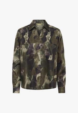 Camicia a maniche lunghe con bottoni, in fantasia camouflage verde, marrone e nera, con due tasche sul petto, su sfondo bianco.