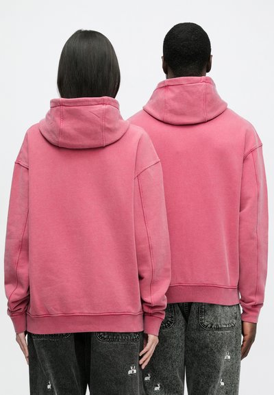 Oversized pink hoodies with a high neck, made of soft fabric. Sweatshirt features dropped shoulders and ribbed cuffs.