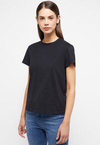 T-shirt in cotone nero con maniche corte e scollatura rotonda. Logo discreto sul lato sinistro del petto, vestibilità rilassata, texture liscia. Stile casual.