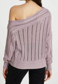 Pull en laine tricotée couleur lavande claire avec un design décolleté, une texture en maille ajourée et des poignets côtelés. Présente des rayures verticales et une coupe décontractée.