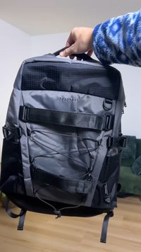 Must ja hall ristkülikukujuline seljakott, millel on reguleeritavad rihmad, esiküljel kummipael ja väike aas kinnitusvahendite jaoks.