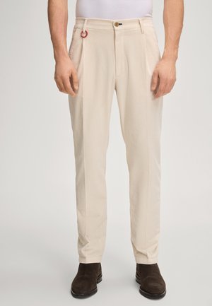 Beige corduroy broek met een slim fit, twee voorzakken, een knoopsluiting en een rood accentringetje aan de riemlus.